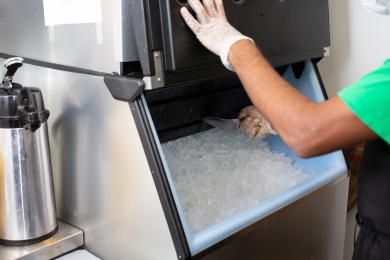 Person scooping ice out of a commercial ice maker