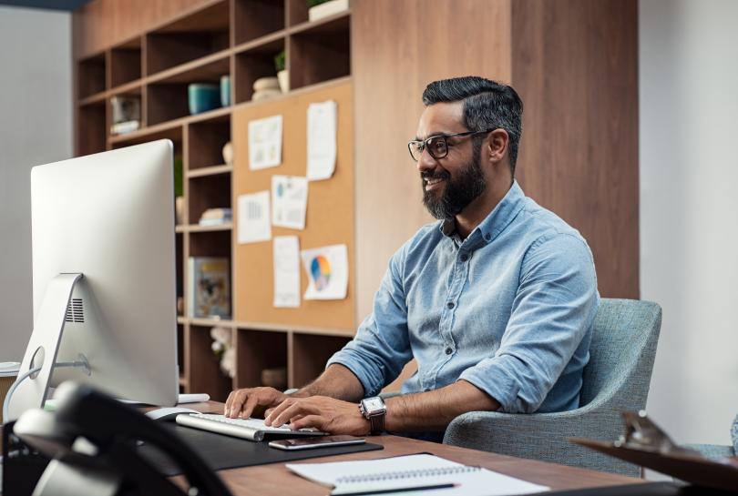 Adult sitting at a desk working on computer