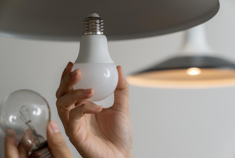 Person replacing incandescent lamp with an LED lamp