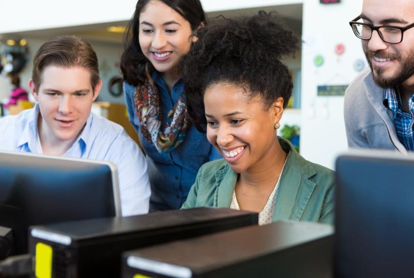 Colleagues around a computer together