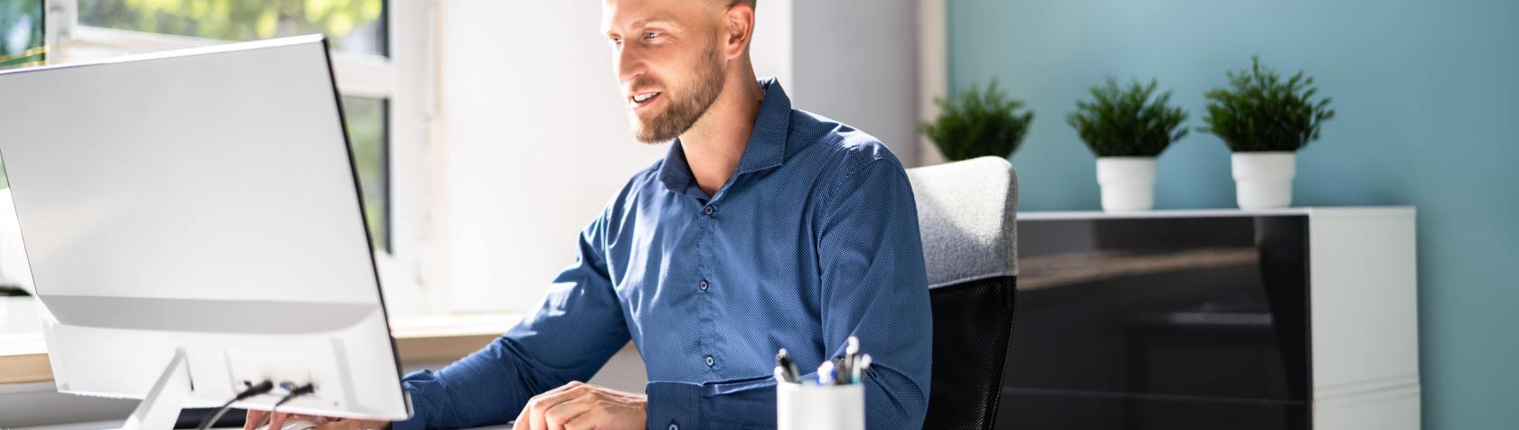 Adult sitting at a desk using a computer in an office