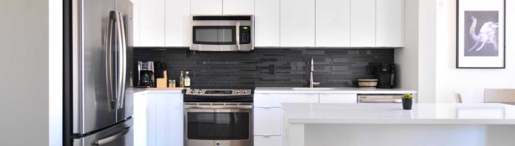 A photo of a kitchen with a fridge on the left