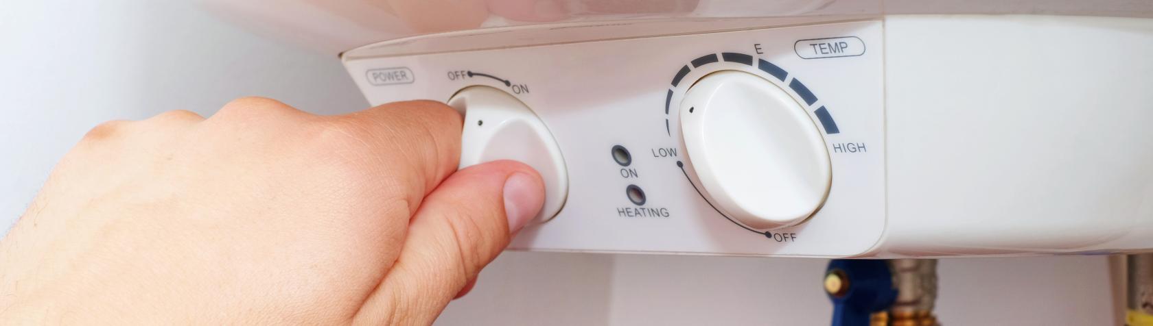 Hand adjusting water heater thermostat 