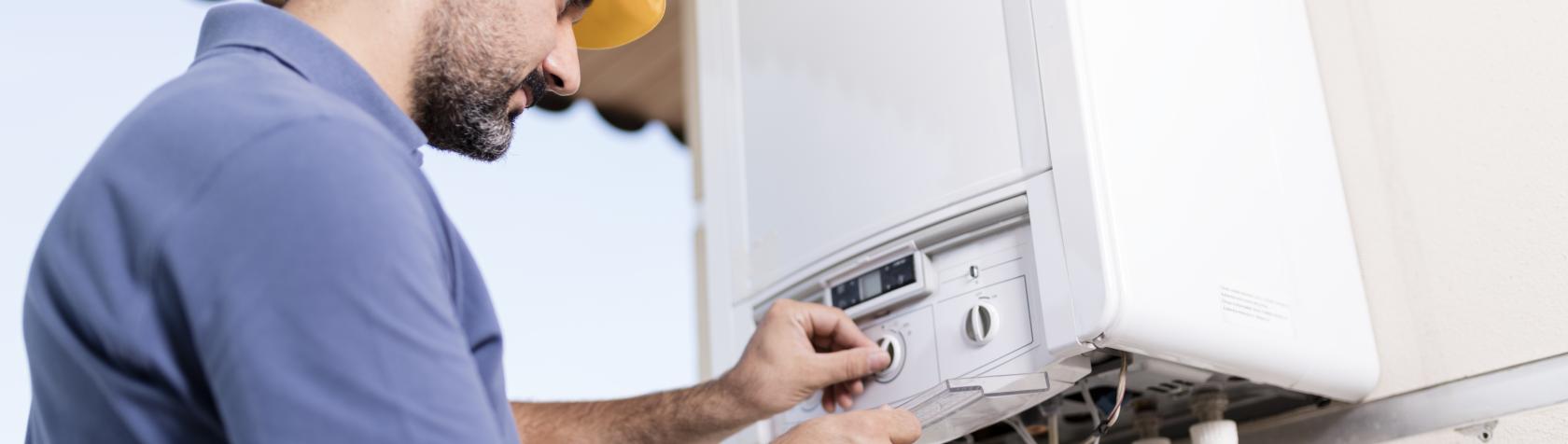 Adult technician adjusting gas water heater