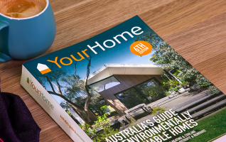 A copy of the Your Home book laying on a coffee table with a mug of coffee